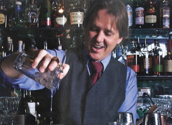 Pouring Stories, Writer Jeff Burkhart Raises the Bar on Stage Barfly Jeff Burkhart stands behind the bar mixing drinks.