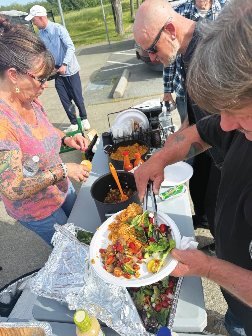 Homeless camp residents break bread together with their housed neighbors at weekly dinners.