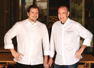 Kitchen Kinship: Chef de Cuisine Reed Palmer Builds on His Father’s Culinary Legacy Reed Palmer and Charlie Palmer in white chef coats.