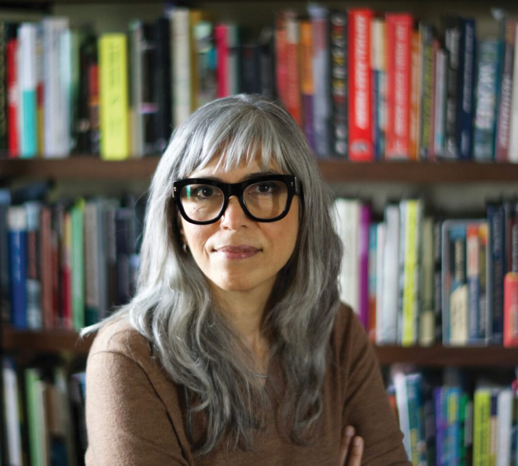 Soraya Murray, author and film scholar, photographed in front of books on shelves.