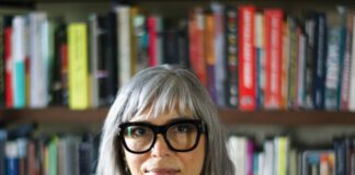 Soraya Murray, author and film scholar, photographed in front of books on shelves.