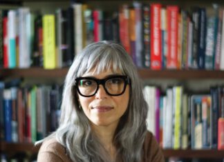 Soraya Murray, author and film scholar, photographed in front of books on shelves.