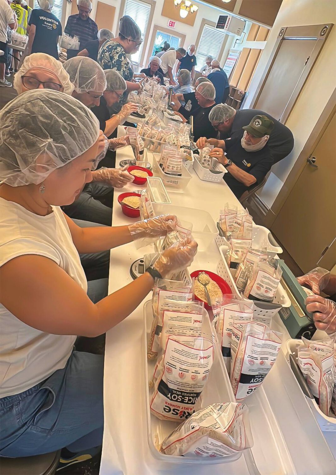 Rotary members take part in a hands-on volunteer effort that helped package 10,000 meals for families in need