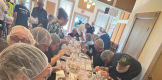 Rotary members take part in a hands-on volunteer effort that helped package 10,000 meals for families in need