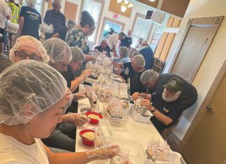 Rotary members take part in a hands-on volunteer effort that helped package 10,000 meals for families in need