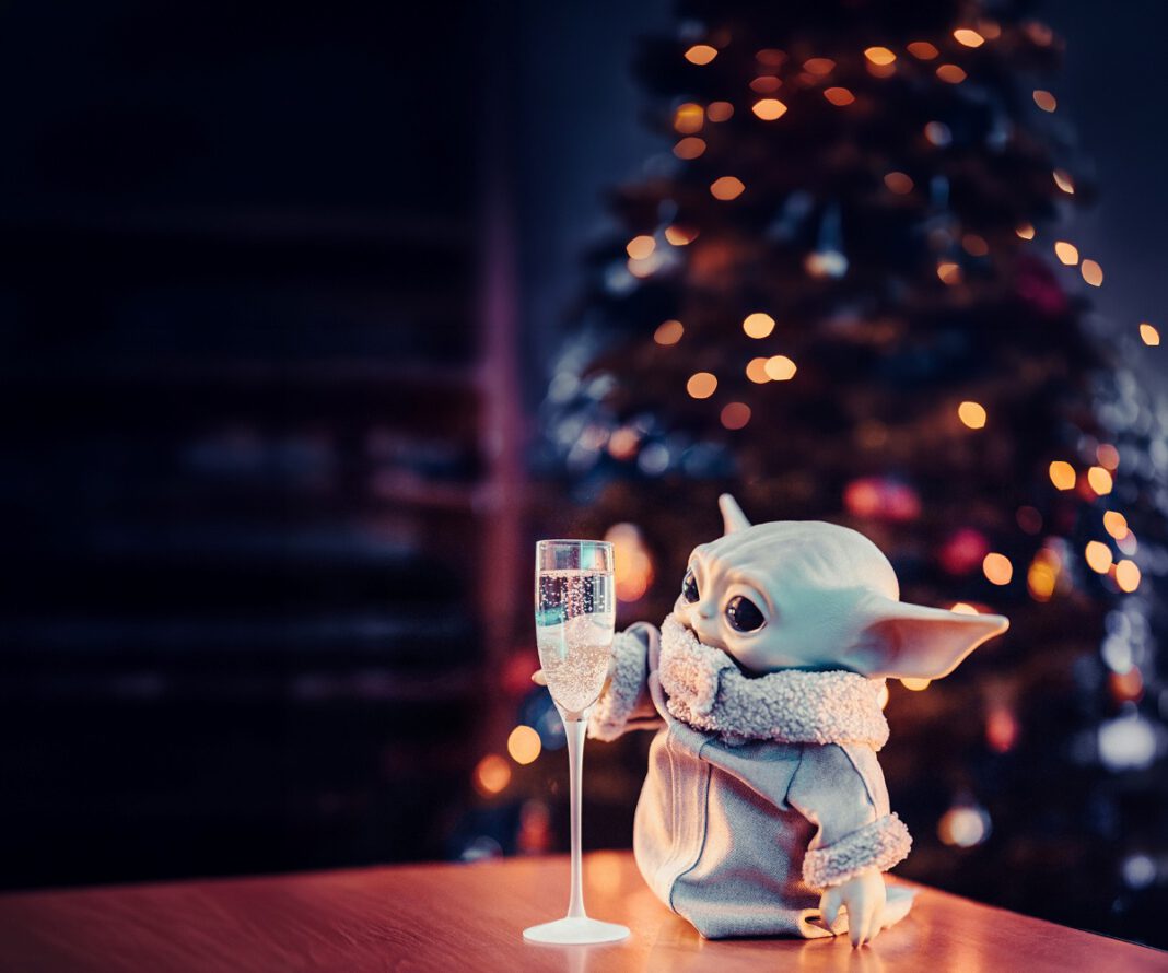 Grogu from Star Wars holding a glass of wine.