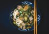 Bowl of noodles with vegetables and meat served with chopsticks