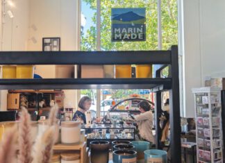 Shop manager assisting a customer inside a retail store filled with locally made products.