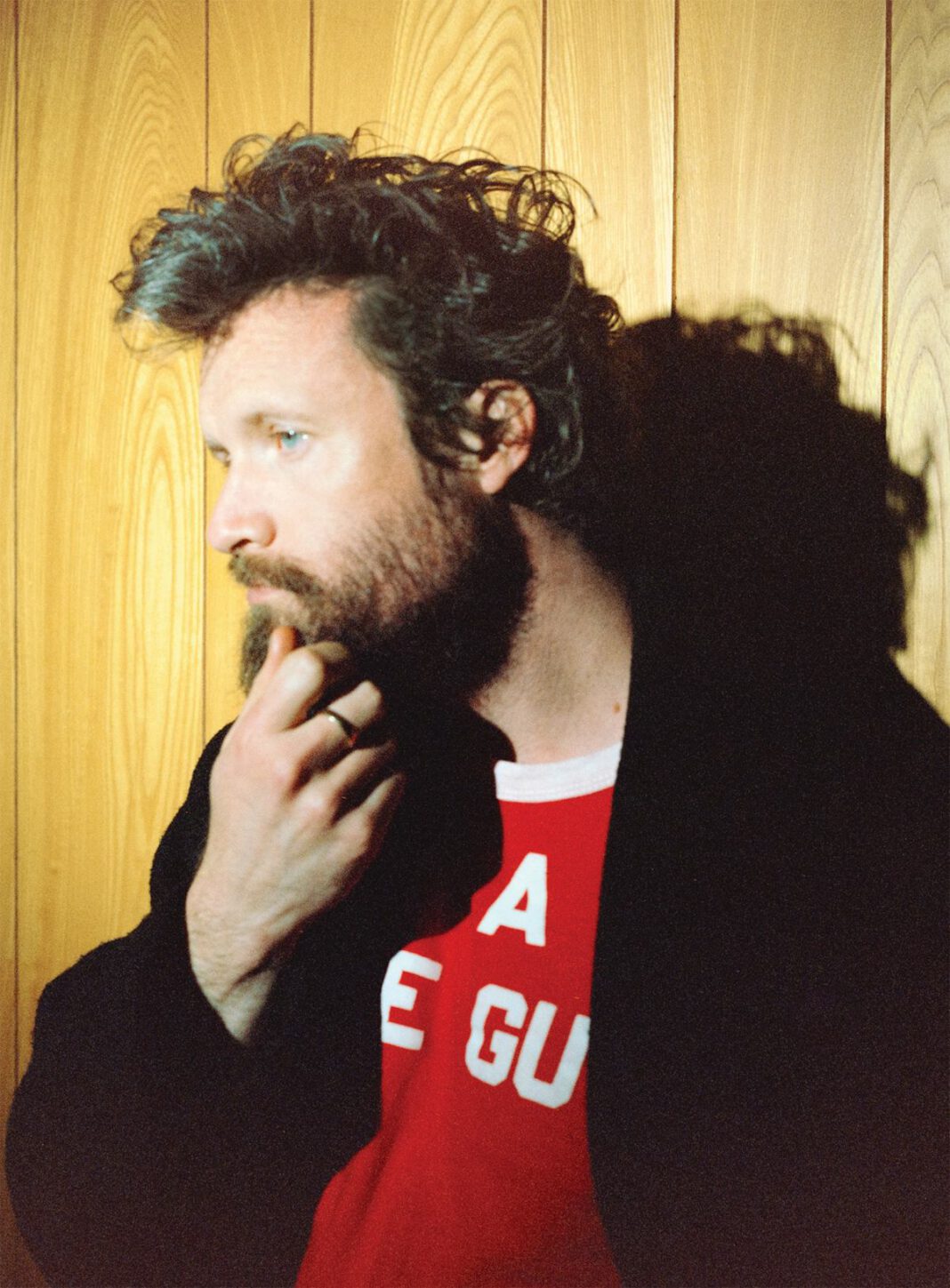 Father John Misty in a red shirt and black jacket.