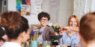 A group of people seated around a table, sharing a meal together.