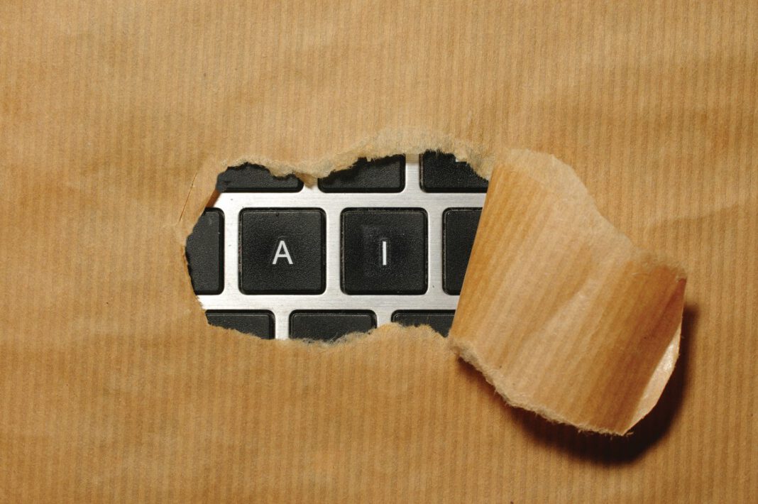 A torn section of brown kraft paper reveals a black computer keyboard with only 