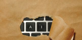 A torn section of brown kraft paper reveals a black computer keyboard with only "A" and "I" keys visible.