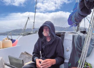 Anchors Away: Richardson Bay’s Last Anchor-Outs An older man in a ball cap sits in the cockpit of a sailboat, looking out over open water.