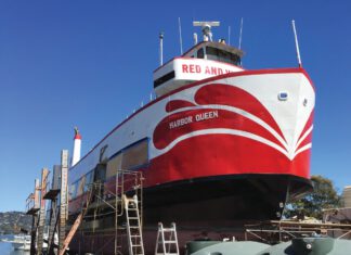 Showdown in Sausalito: Voters Decide Who Will Rule the Waterfront A red and white boat named Harbor Queen sits out of the water in a boatyard, surrounded by scaffolding and ladders.